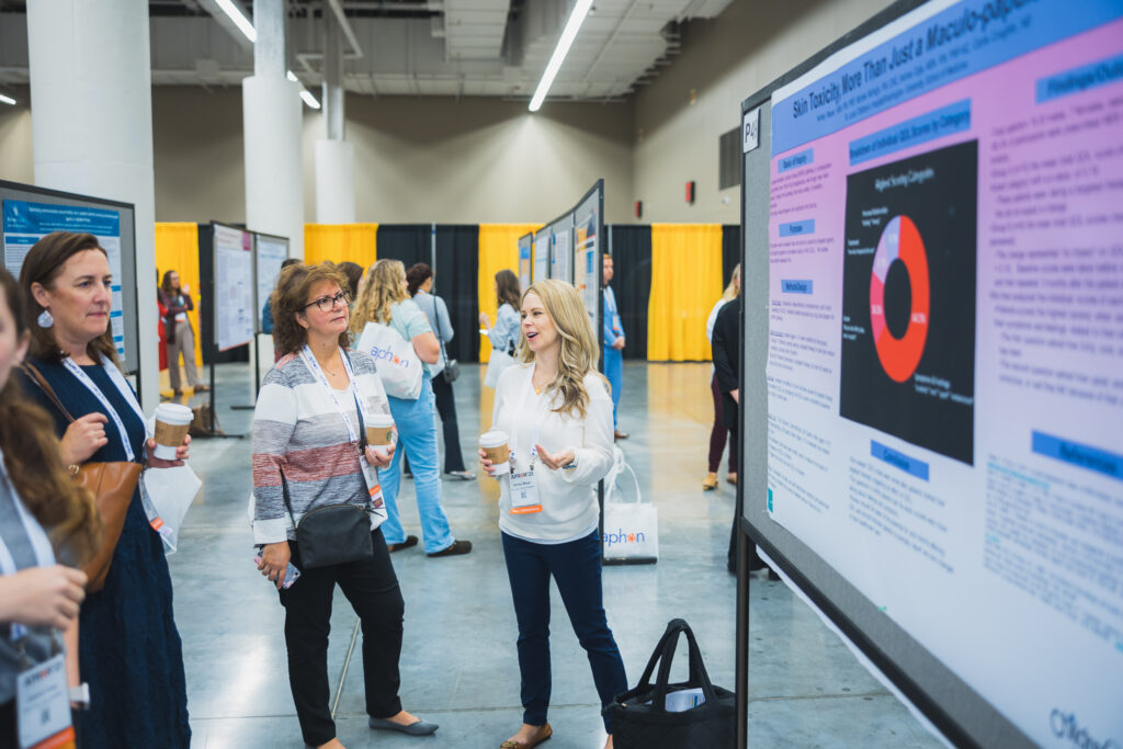 Image of attendees approaching an abstract poster at an APHON annual conference.